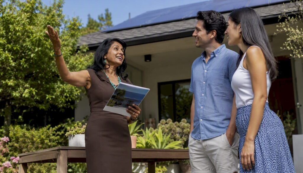 Agent explaining solar panels to homebuyers outside house